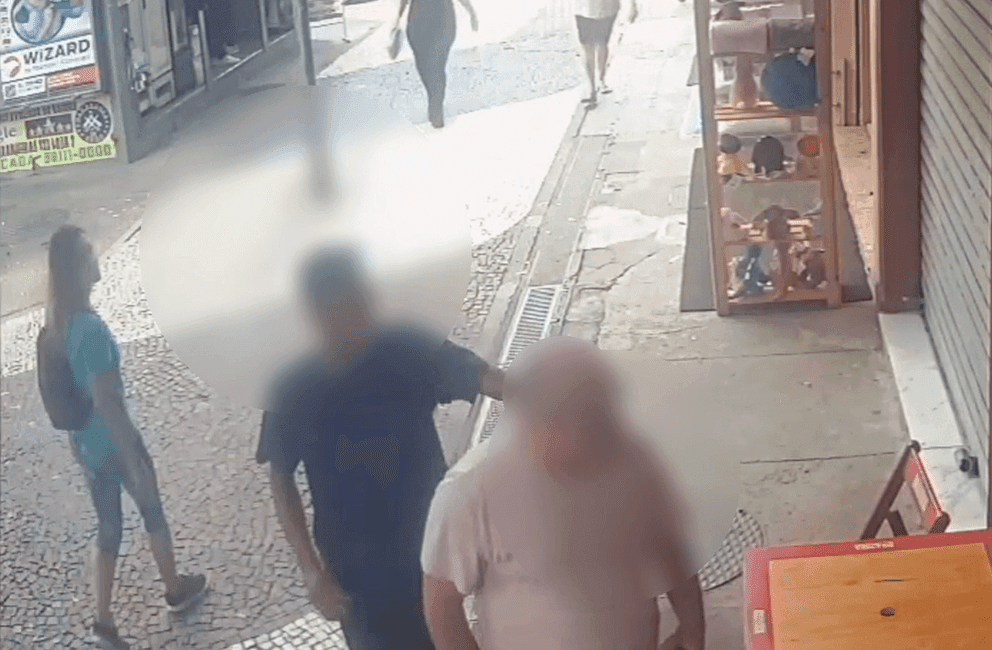 Um dos criminosos puxa o cordão da vítima