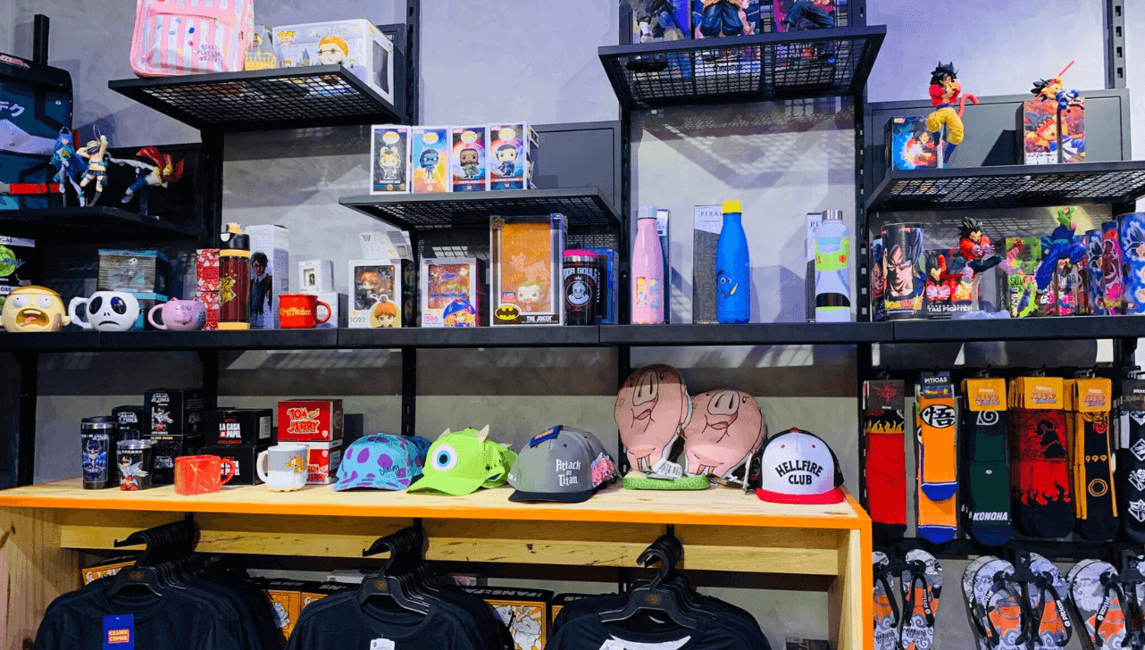Prateleiras com camisetas, bonés, copos e colecionáveis que reúnem diferentes referências da cultura pop