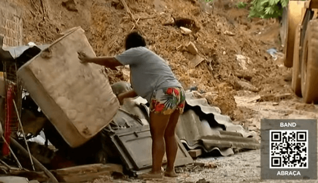 Moradora retira objetos danificados em enchente em Recife 