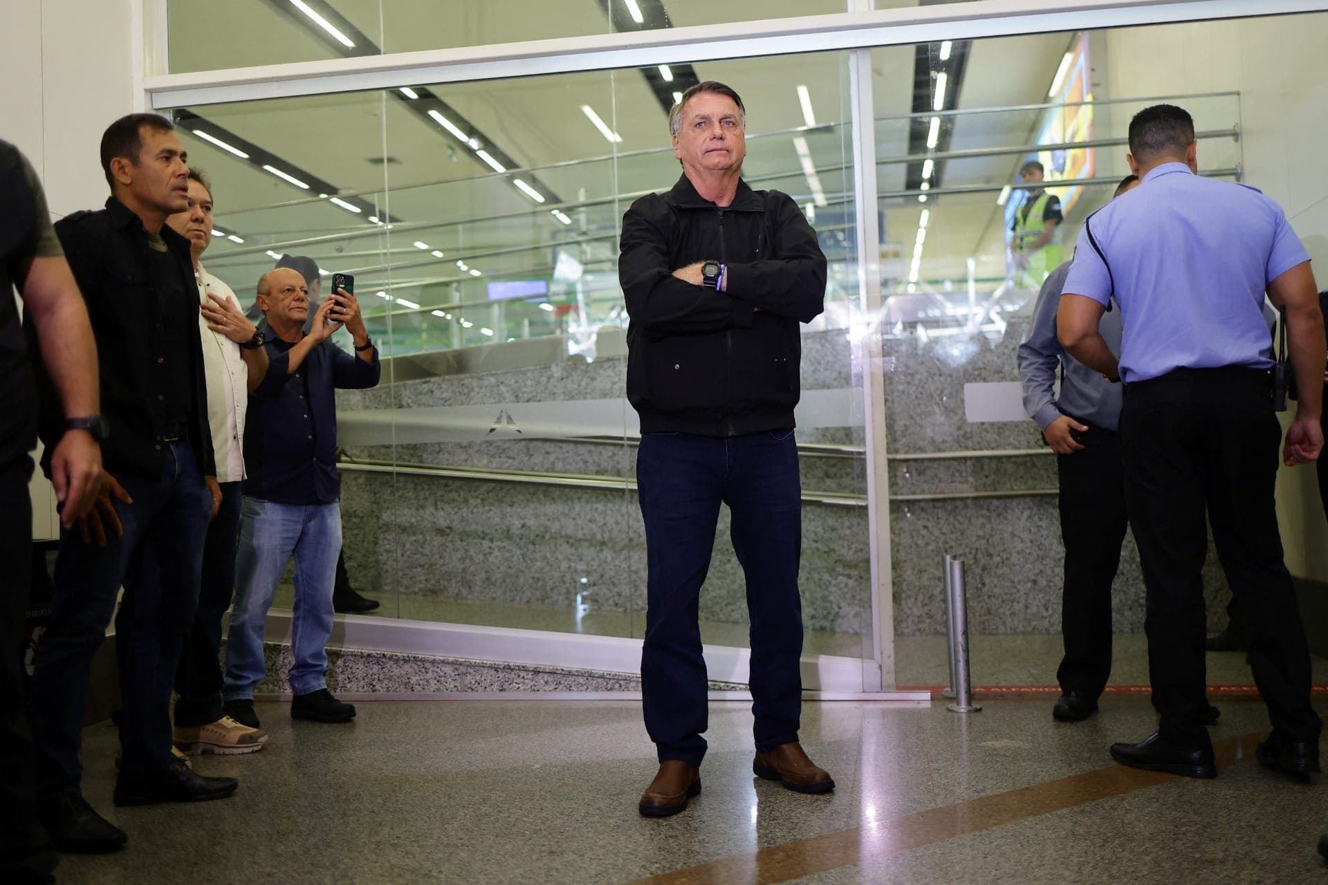 Jair Bolsonaro após se despedir de sua esposa Michelle Bolsonaro enquanto ela embarca para a posse do presidente dos EUA, Donald Trump, no Aeroporto Internacional de Brasília, neste sábado (18)