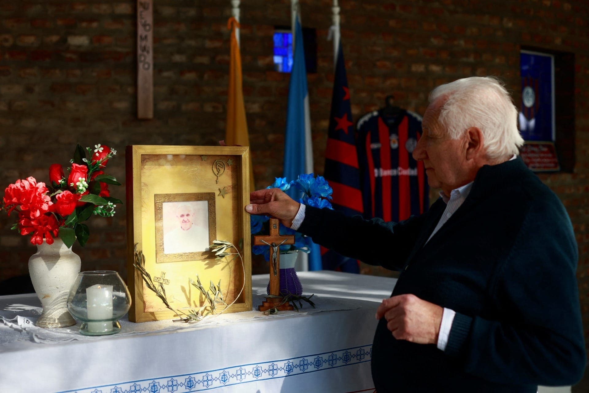 Oscar Lucchini, responsável pela capela do San Lorenzo de Almagro, time de futebol da cidade natal do Papa Francisco, segura uma foto do pontífice após sua morte, em Buenos Aires