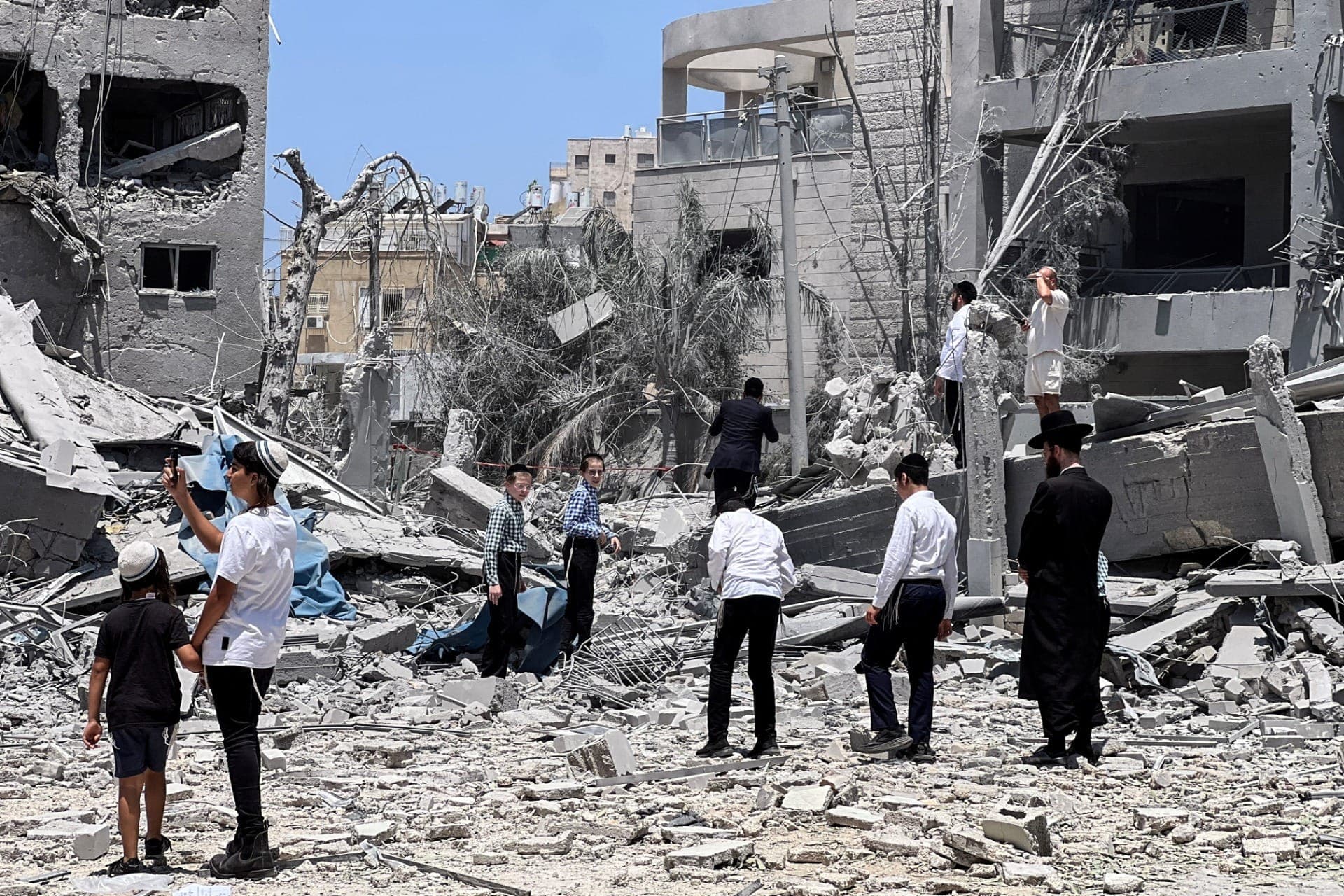 Israelenses observam o local atingido após um ataque com mísseis do Irã contra Israel, em Bnei Brak