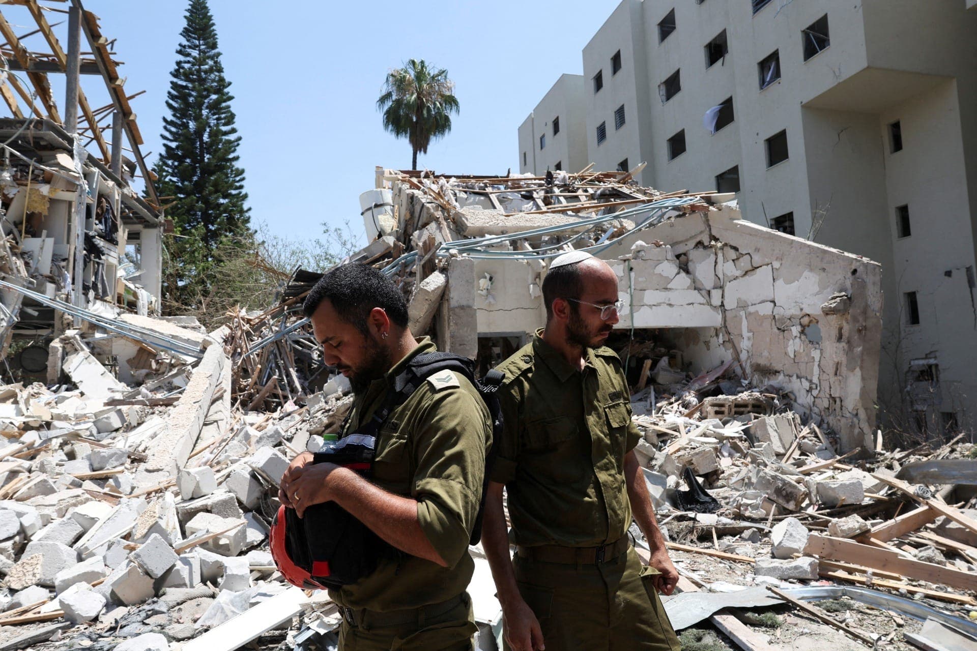 Membros das forças israelenses trabalham em um local de impacto após um ataque com mísseis do Irã contra Israel, em Tel Aviv