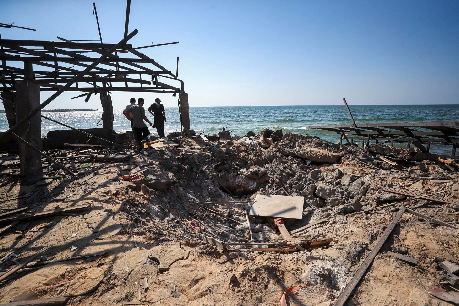 Palestinos inspecionam o local de um ataque aéreo israelense à cafeteria Al-Baqa, segundo o Ministério da Saúde de Gaza, no oeste da Cidade de Gaza