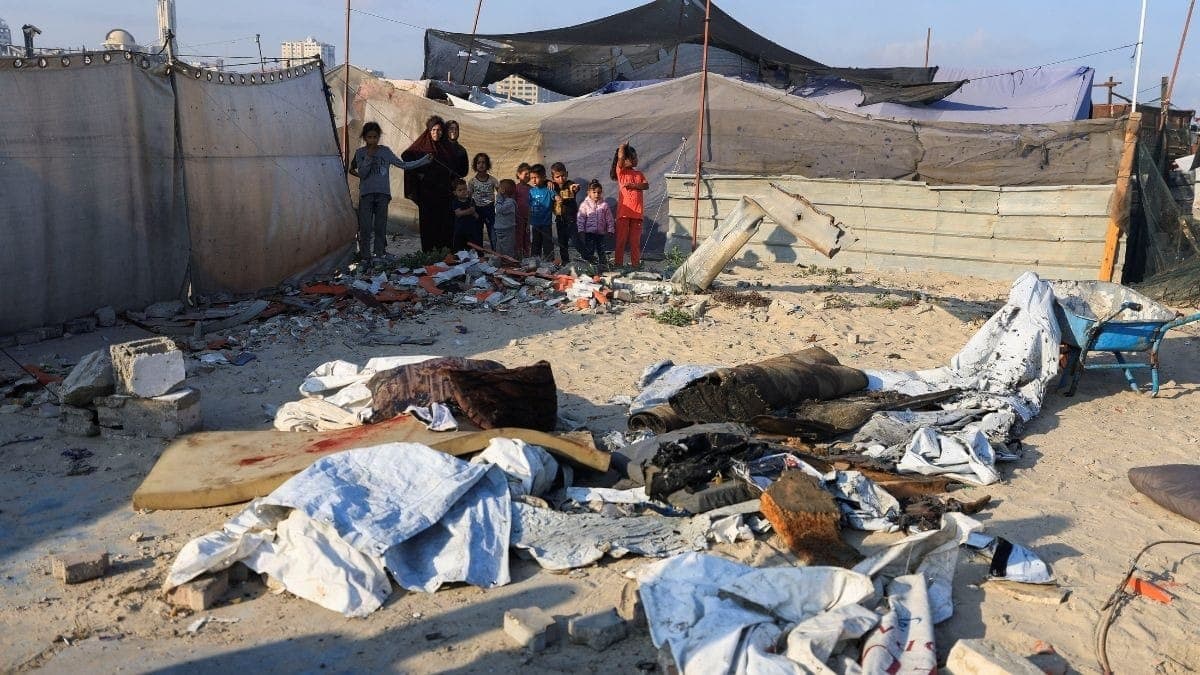 Palestinos inspecionam os danos no local de um ataque aéreo israelense