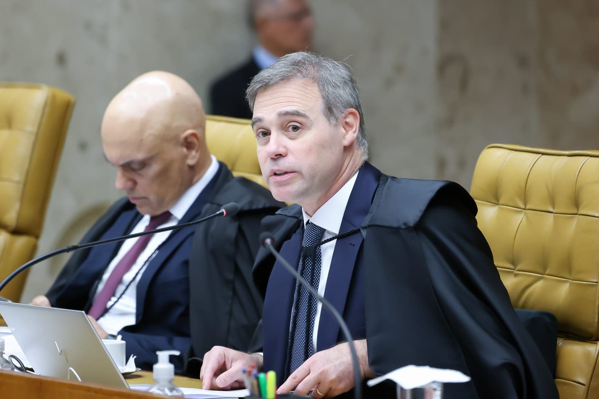 Ministro André Mendonça, e ao fundo o ministro Alexandre de Moraes, ambos do Supremo Tribunal Federal