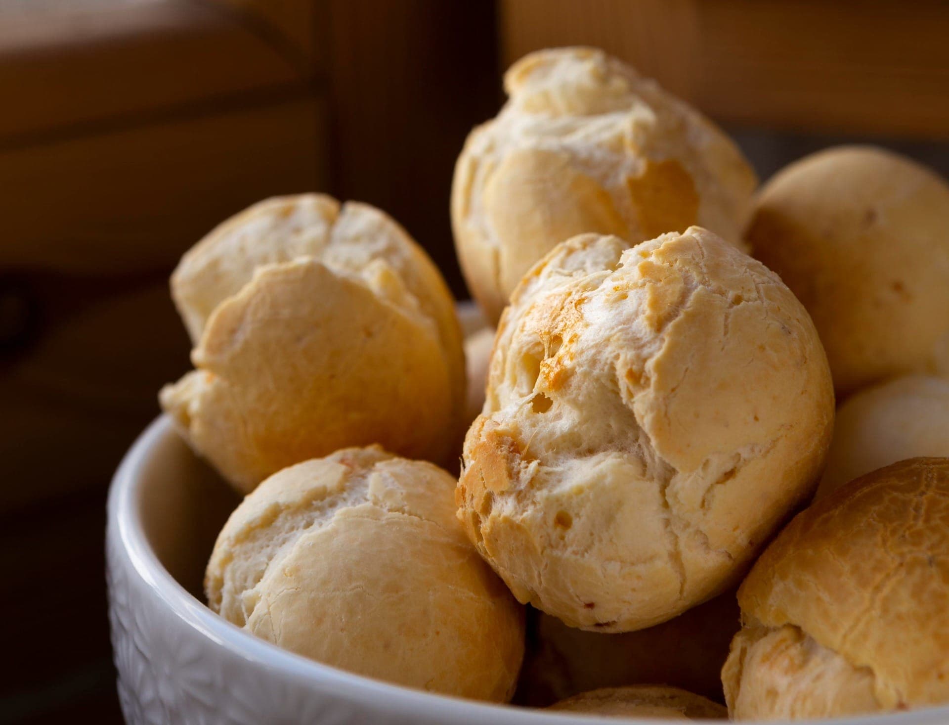 O segredo para um pão de queijo aerado, macio por dentro e com aquela casquinha dourada irresistível está em um passo clássico: escaldar o polvilho azedo com os líquidos ferventes