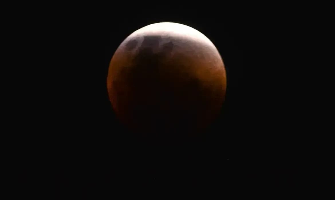 Lua aparece parcialmente encoberta durante eclipse lunar; fase total não será visível na maior parte do Brasil