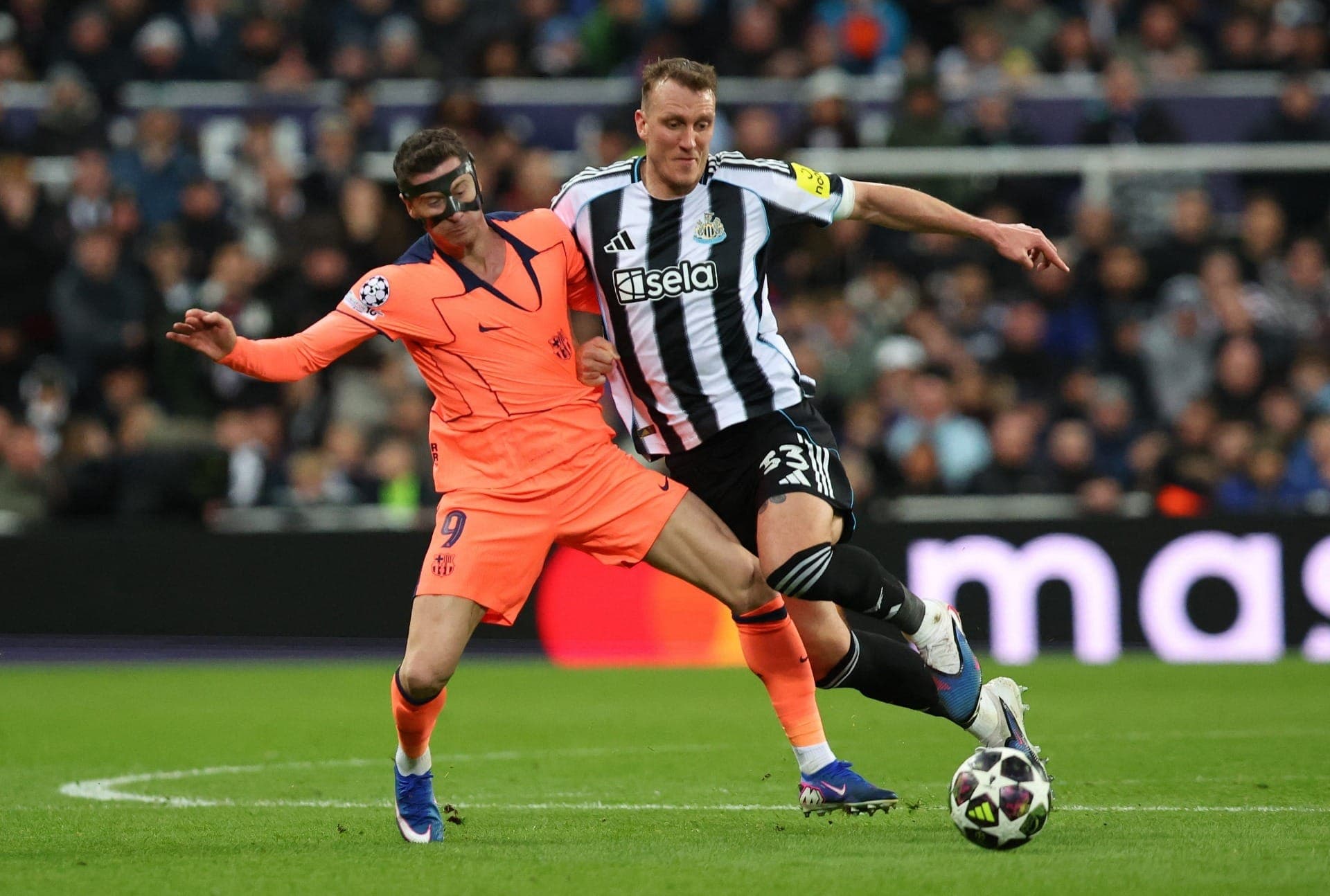 Lewandowski, do Barcelona, em ação contra Dan Burn, do Newcastle