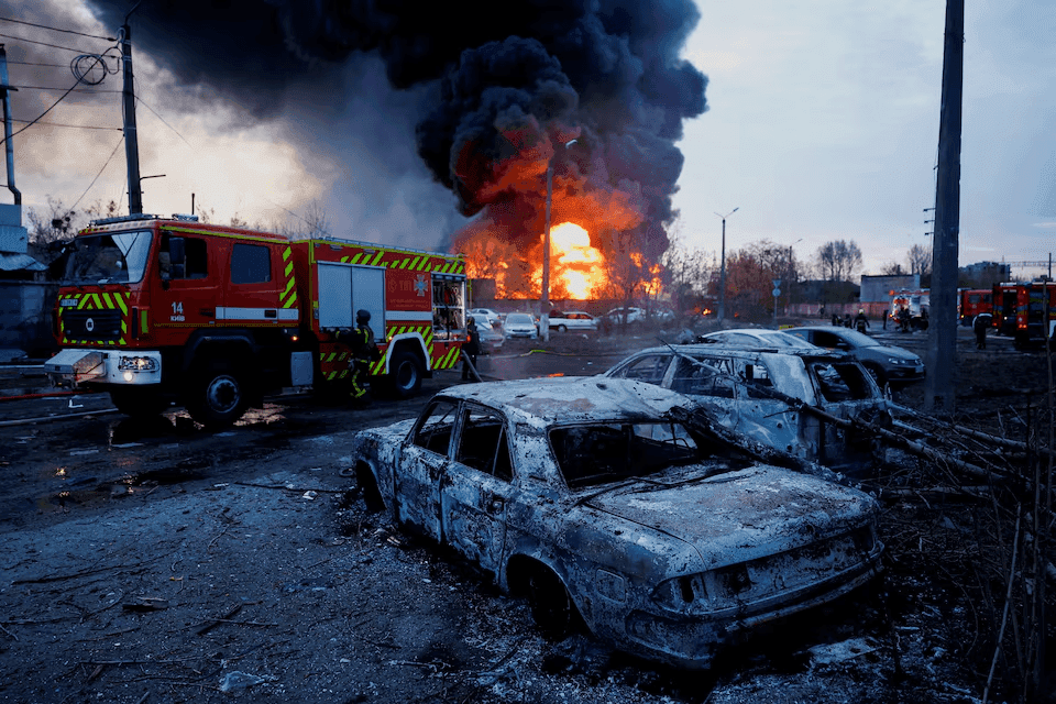 Bombeiros trabalham próximo a carros destruídos por ataques russos em Kiev, em 16 de abril