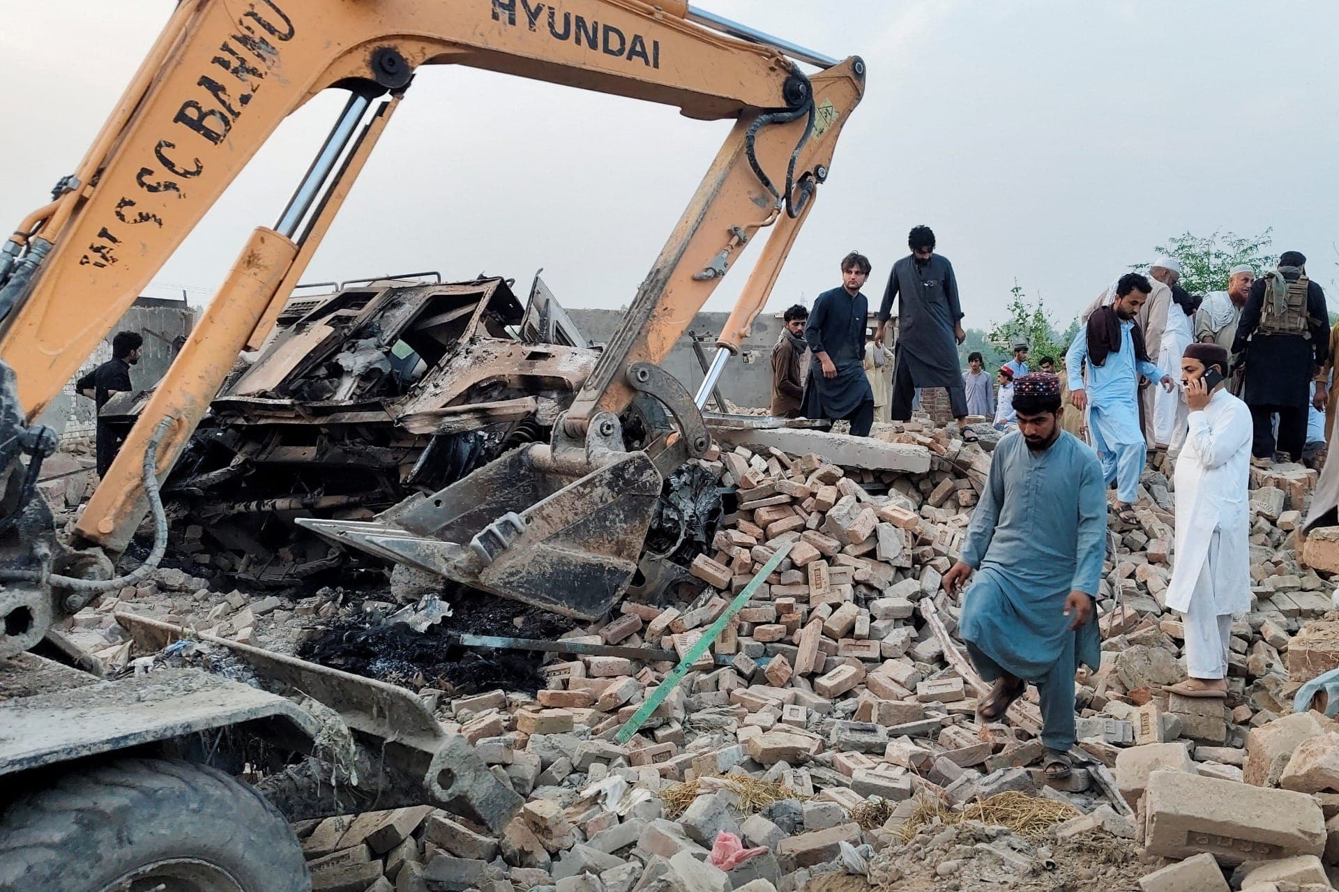 Moradores se reúnem sobre os escombros de um posto policial danificado após um atentado com carro-bomba em Bannu, na província de Khyber Pakhtunkhwa, no Paquistão