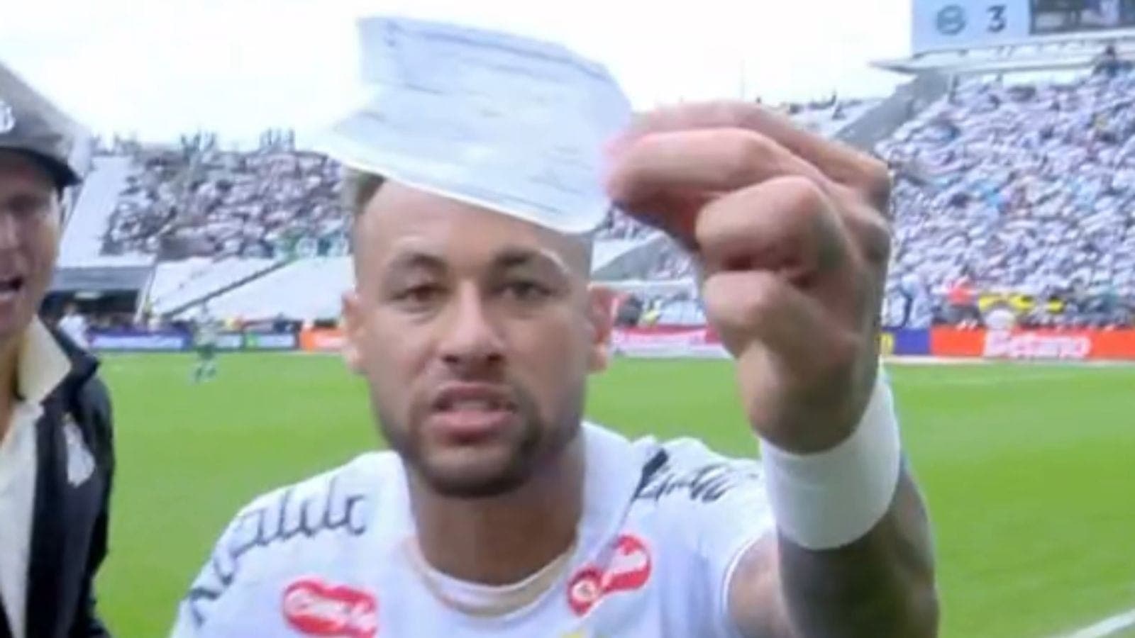 Neymar mostra o papel da substituição para a câmera de transmissão