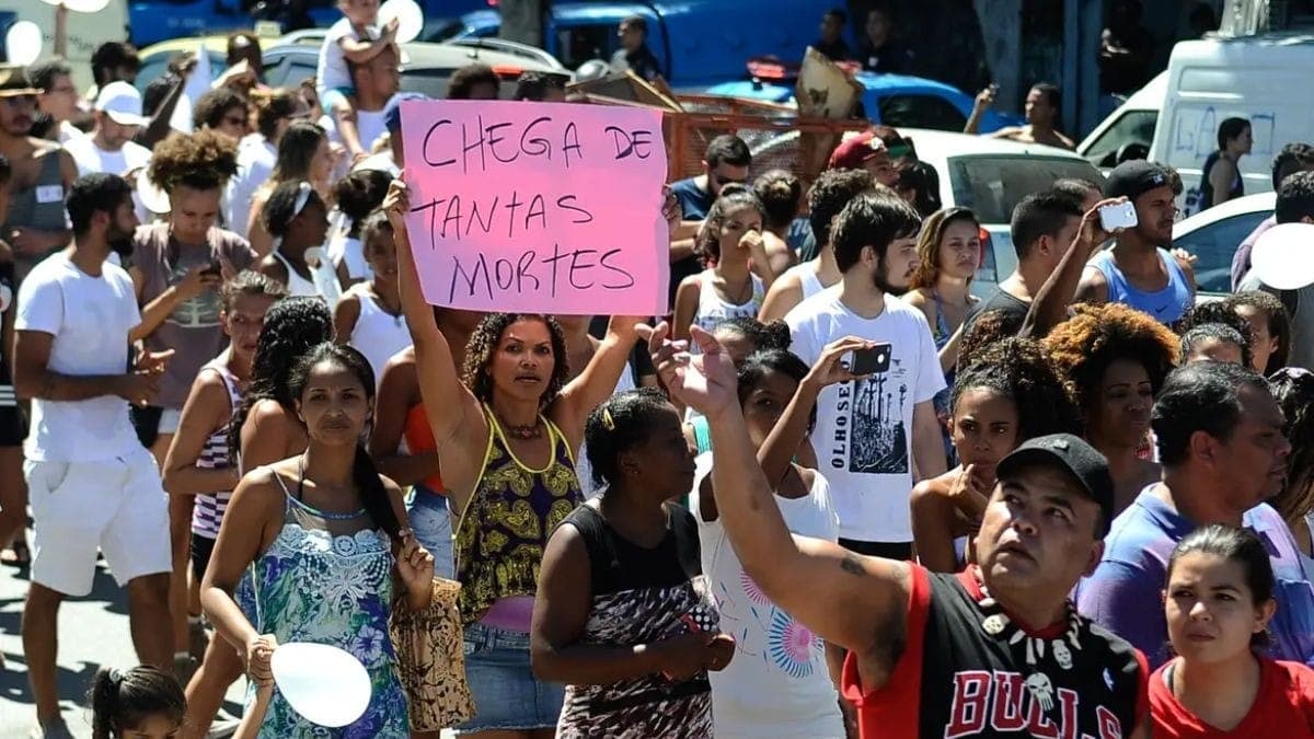 Mulher segura cartaz com a frase: ‘Chega de tantas mortes’