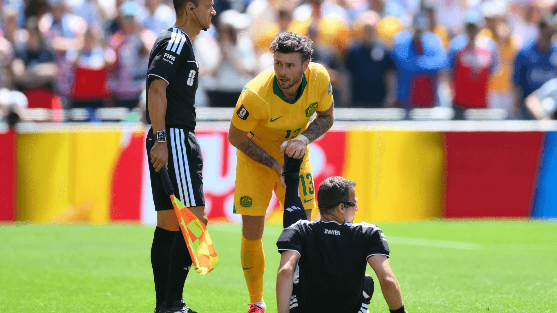 Felix Zwayer recebe ajuda do jogador da Austrália Aiden O'Neill após sentir desconforto na perna esquerda