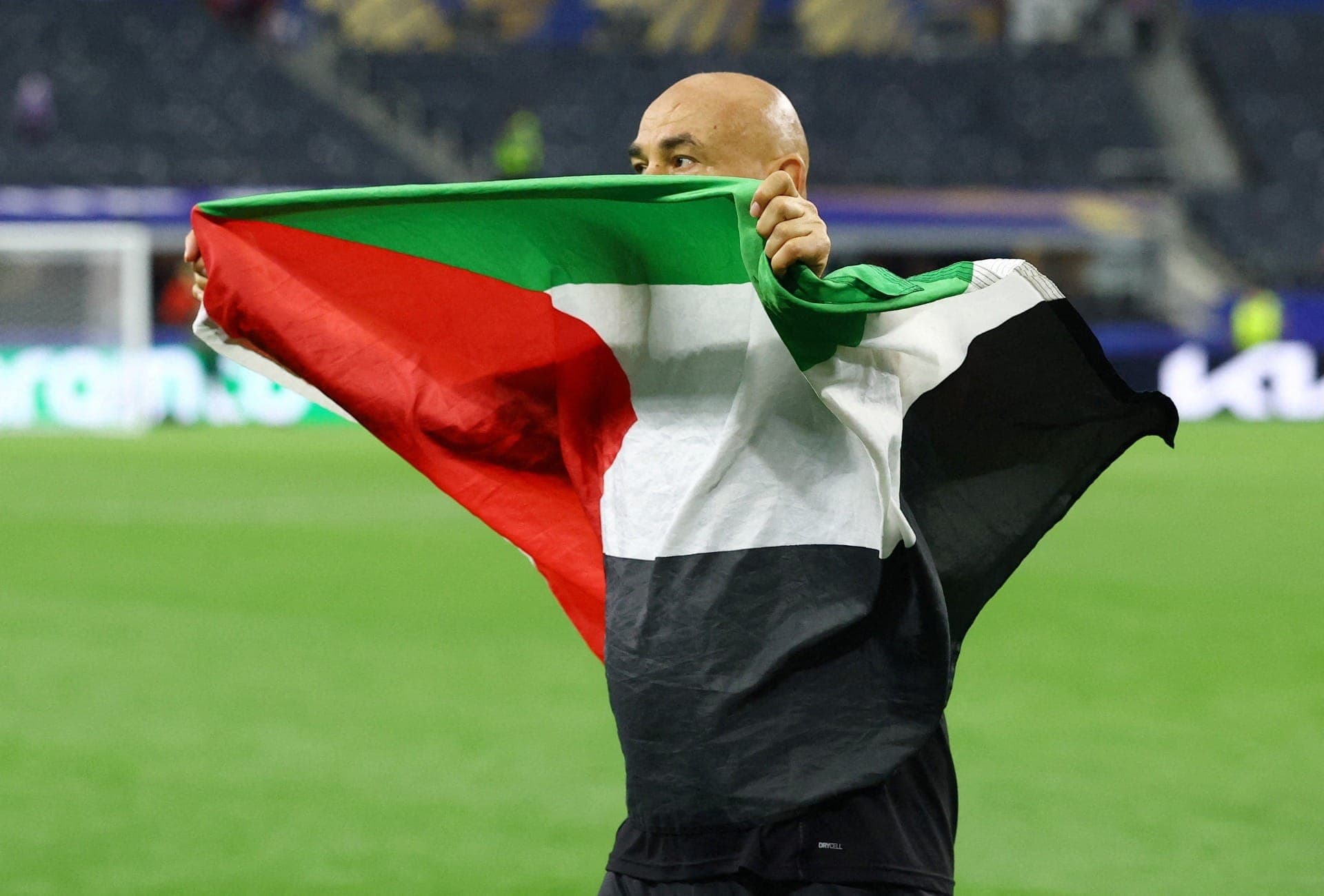 Técnico do Egito, Hossam Hassan, com bandeira palestina após jogo na Copa