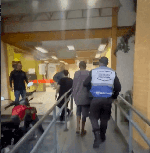 Homem sendo preso após roubar bacalhau