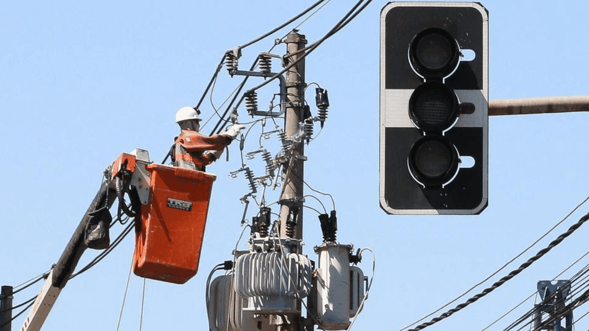 Funcionários da Enel fazem manutenção em poste de energia elétrica