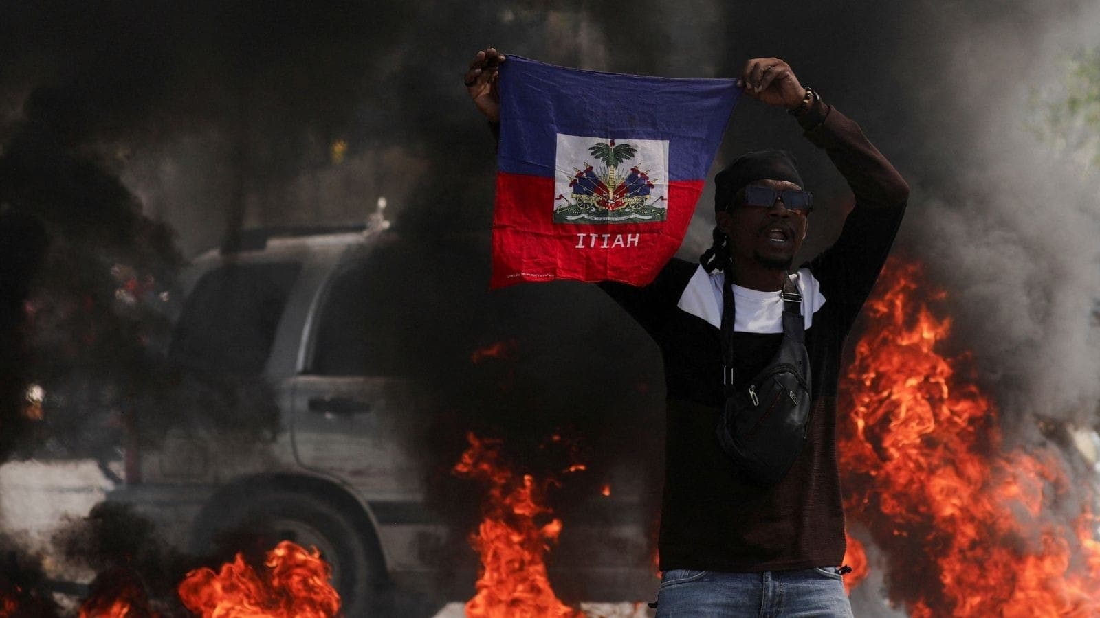 Manifestante com bandeira do Haiti durante protesto em Porto Príncipe
