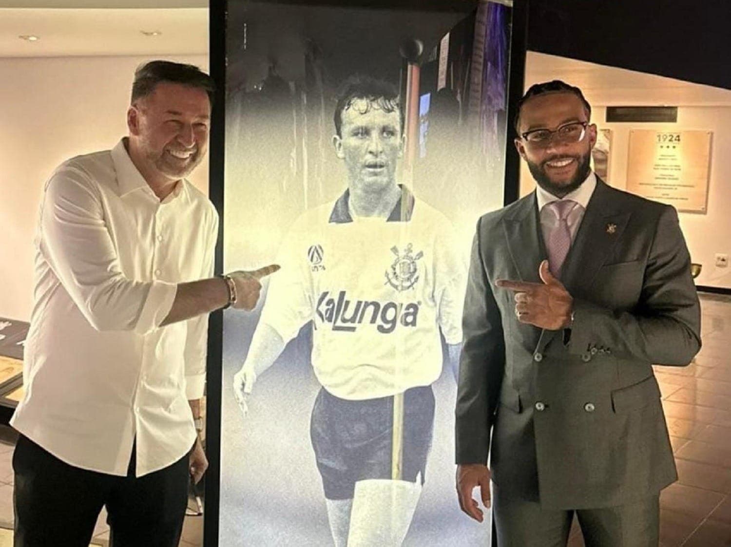 Memphis Depay e Augusto Melo ao lado de imagem de Neto no Parque São Jorge
