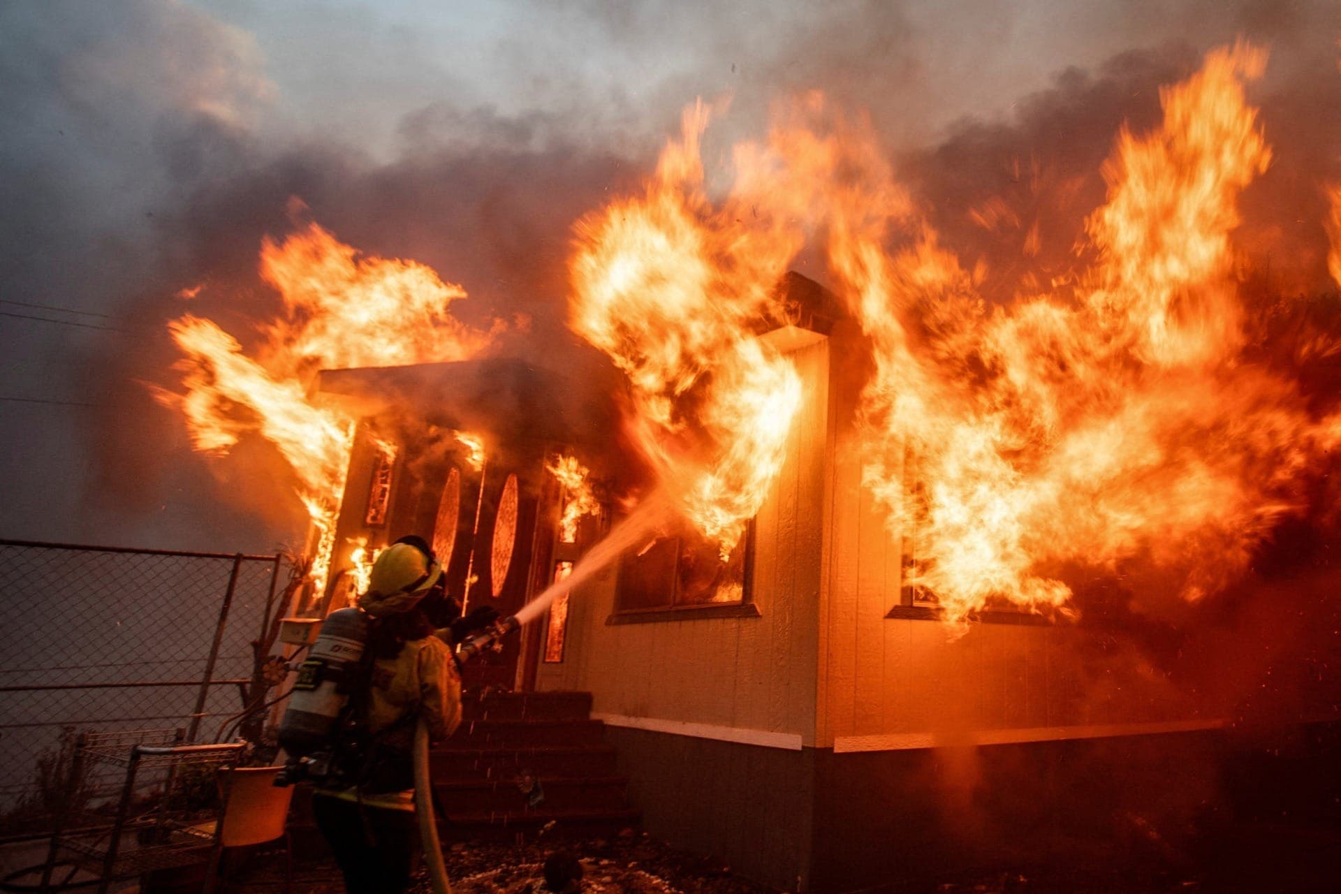 Bombeiro luta contra o incêndio Palisades enquanto queima durante uma tempestade de vento em Los Angeles